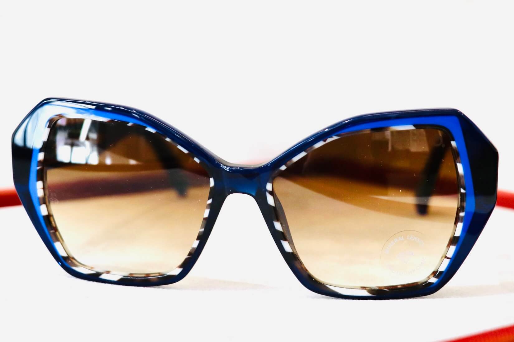 Brillentrends im Herbst 2024_Sonnenbrille mit blau, braunem Rahmen und eckiger Cateye-Anmutung