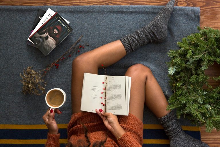 Eine sitzende Frau mit grauen Socken, die ein Buch liest