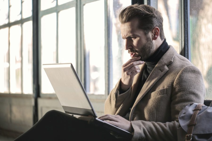 Ein Mann, der angestrengt auf sein Notebook schaut