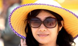 Augengesundheit im Sommer steigern durch den optimalen Schutz eines Sommerhutes wie die Frau mit Sonnenbrille