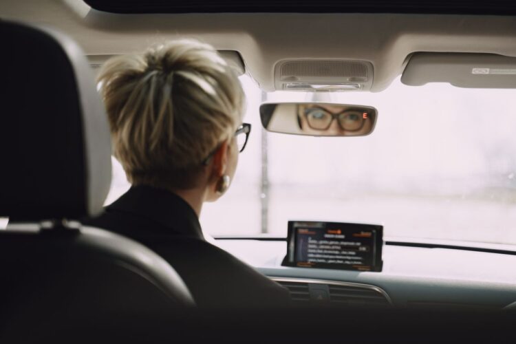 pexels-photo-4127528-4127528 Back view of unrecognizable short hair female driver in formal clothes and eyeglasses riding car while looking at rear mirror
