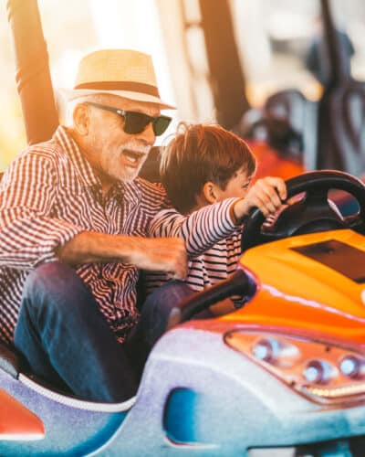 Großvater mit Enkel beim Auto-Scooter-Fahren